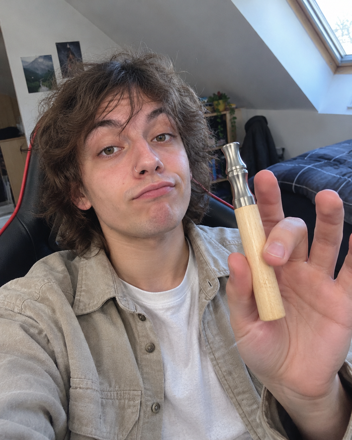 Young adult holding a maple Luft in their room